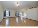 Spacious living room with wood floors, large windows, and a ceiling fan at 546 Treyburn Lakes Way, Indianapolis, IN 46239