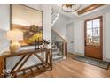 Inviting entryway with hardwood floors, stairs, modern lighting, and a stylish console table at 583 Exmoor Dr, Carmel, IN 46032