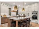 Gourmet kitchen featuring a large island with seating, stainless steel appliances, and custom cabinetry at 583 Exmoor Dr, Carmel, IN 46032