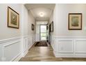Inviting entryway with wood flooring, white wainscoting, and decorative framed artwork on the walls at 5875 Mill Haven Way, Noblesville, IN 46062