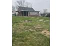 The backyard features ample green space, fire pit, and potential for outdoor activities at 6206 W Us Highway 40, Stilesville, IN 46180