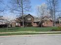 Inviting brick home with beautiful landscaping and a manicured lawn, complete with an American flag at 6712 Forrest Commons Blvd, Indianapolis, IN 46227