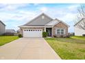 Traditional home exterior featuring a brick facade, manicured lawn, and an attached two-car garage beneath a partly cloudy sky at 7574 Merrick Dr, Brownsburg, IN 46112