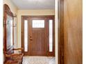 Inviting entryway featuring a solid wood front door and an antique coat rack with mirror at 920 Mellowood Dr, Indianapolis, IN 46217