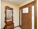 Inviting entryway featuring a solid wood front door and an antique coat rack with mirror at 920 Mellowood Dr, Indianapolis, IN 46217