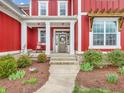 Inviting covered porch with white columns, a decorative wreath, and lush landscaping offering great curb appeal at 10603 Hinterland Dr, Fishers, IN 46038