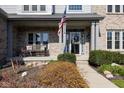 Inviting front porch with a swing and American flag, creating a warm and welcoming entrance at 11050 Midnight Pass, Fishers, IN 46037
