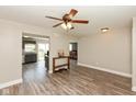 Open-concept living space featuring wood-look floors, a ceiling fan, and an adjoining kitchen at 1167 Dark Star Ct, New Whiteland, IN 46184