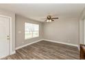 Bright living room featuring wood-look flooring, a ceiling fan, and a window offering natural light at 1167 Dark Star Ct, New Whiteland, IN 46184