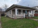 Cozy home with covered porch and vinyl siding, complemented by a compact front lawn at 1524 Ohio Ave, Anderson, IN 46016