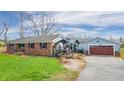 Rear view of the property featuring a spacious garage, a cozy seating area and a brick house at 16371 State Road 38 E, Noblesville, IN 46060