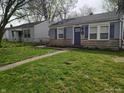 Charming one-story home with stone accents, blue shutters, and a well-maintained lawn at 1806 Asbury St, Indianapolis, IN 46203
