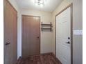 Entryway featuring hardwood floors, coat closet, white paneled door, and decorative shelf at 235 E County Line Rd, Greenwood, IN 46143