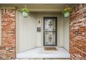 Inviting front porch with hanging flower baskets, decorative door, and 'Happy Hour' welcome mat at 235 E County Line Rd, Greenwood, IN 46143