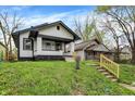 Street view of a charming house with black and white trim and a grassy lawn leading up to the house at 2915 E 19Th St, Indianapolis, IN 46218