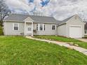 Inviting single-Gathering home featuring tidy landscaping, vinyl siding, and a detached single-car garage at 2920 Lincoln St, Anderson, IN 46016