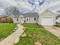 A charming house featuring vinyl siding, a lush lawn, and a convenient detached one-car garage at 2920 Lincoln St, Anderson, IN 46016