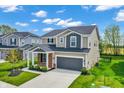 Well-manicured two-story home with a gray garage door, brick accents, and a beautiful lawn in a desirable neighborhood at 4941 Oak Hill Dr, Lebanon, IN 46052