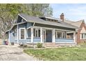 Charming blue home with a cozy front porch and well-maintained landscaping at 5028 Graceland Ave, Indianapolis, IN 46208