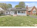 Quaint home featuring a covered porch, freshly cut lawn, and a peaceful residential setting at 5028 Graceland Ave, Indianapolis, IN 46208