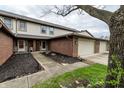 Charming townhome with brick accents, featuring a welcoming entrance and attached garage at 5367 Cotton Bay W Dr, Indianapolis, IN 46254
