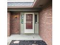 Close-up of a home's exterior featuring a brick facade and front door with sidelights at 5367 Cotton Bay W Dr, Indianapolis, IN 46254