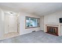 Bright living room with a painted brick fireplace, large windows, and neutral carpeting at 5734 Hillside Ave, Indianapolis, IN 46220