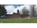 View of the rear of the house with an outbuilding and vehicles parked on the grounds at 5736 W 300 S, Anderson, IN 46011