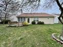 A spacious backyard featuring a wooden deck, lush green grass, and tidy landscaping at 6083 White Birch Dr, Fishers, IN 46038