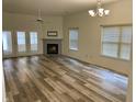 Bright and airy living room with a fireplace, vinyl flooring, and French doors to the patio at 6083 White Birch Dr, Fishers, IN 46038