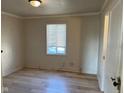 Bedroom with light wood floors, a window with blinds, and neutral walls at 635 Laclede St, Indianapolis, IN 46241
