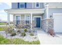Inviting front entrance with stone accents, manicured landscaping and an attractive blue front door at 7140 Leatherwood Dr, Indianapolis, IN 46259