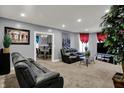 Inviting living room with gray walls, plush carpeting, and comfortable black leather reclining sofas at 725 N Sheffield Ave, Indianapolis, IN 46222