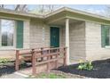 Close-up view of the front door, stone facade, green shutters, and a small ramp at 7575 Holliday W Dr, Indianapolis, IN 46260