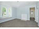Spacious living room featuring neutral carpet, large windows, fireplace, and fresh paint at 804 N California St, Indianapolis, IN 46202