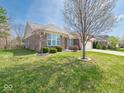 Attractive brick home boasting a lush green lawn and professionally designed landscaping at 9831 N Port Dr, McCordsville, IN 46055