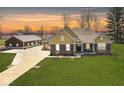 Charming front exterior featuring a well-manicured lawn, an attached three car garage, and a large storage building at 10151 E 191St St, Noblesville, IN 46060