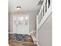 Inviting entryway with hardwood floors, staircase, and a front door with sidelights at 10234 Leeward Blvd, Indianapolis, IN 46256