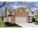 Side view of a charming two-story home with brick and siding and an attached two-car garage at 10234 Leeward Blvd, Indianapolis, IN 46256