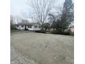 Wide shot of the single story home with gravel driveway and landscaping at 1024 Foltz St, Indianapolis, IN 46241