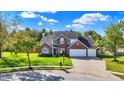 Beautiful brick home with a three-car garage and lush green lawn at 10401 Monarch Ct, Noblesville, IN 46060