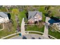 Aerial view of a beautiful brick home with lush green lawn and mature trees in a desirable neighborhood at 10611 Proposal Pointe Way, Fishers, IN 46040