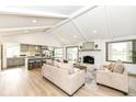 Bright, open-concept living room with vaulted ceilings, fireplace, hardwood floors, and seamless flow to the updated kitchen at 107 Northwood Dr, Fishers, IN 46038