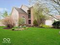 Beautifully landscaped two-story home with brick accents and a lush green lawn at 13921 Leatherwood Dr, Carmel, IN 46033