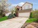 Two-story home with a two-car garage, brick accents, and a spacious driveway at 13921 Leatherwood Dr, Carmel, IN 46033