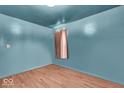 Empty room featuring hardwood floors and walls painted in a soft blue hue at 1441 N Euclid Ave, Indianapolis, IN 46201