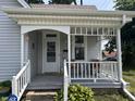 A close up of the front porch featuring a cozy sitting area and well-maintained white railings, adding curb appeal at 159 N Lincoln St, Martinsville, IN 46151