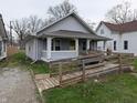 Exterior view of a light blue single-story home featuring a charming front porch and an accessible ramp at 1830 Nichol Ave, Anderson, IN 46016