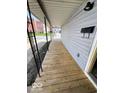 Covered porch with wood flooring, rod iron supports, a mailbox, and an outlet at 2111 Central Ave, Anderson, IN 46016