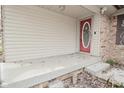 Covered front porch featuring a red front door, vinyl siding, and a poured concrete step at 218 Demarest Dr, Indianapolis, IN 46214